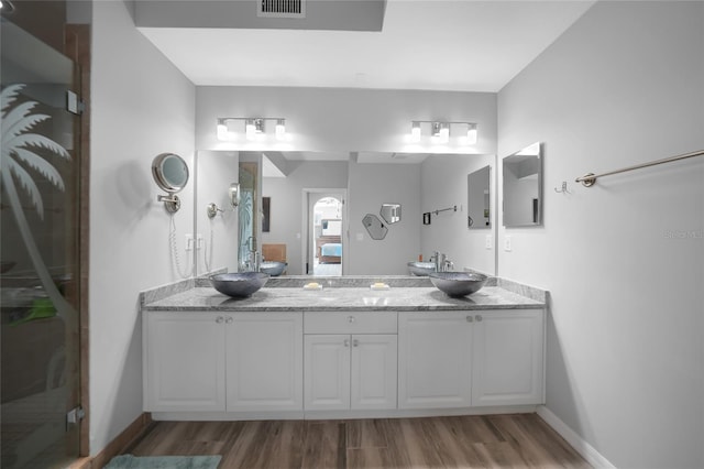 bathroom featuring hardwood / wood-style flooring, vanity, and an enclosed shower