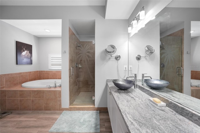 bathroom featuring hardwood / wood-style floors, vanity, and separate shower and tub