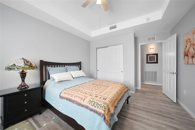 bedroom featuring ceiling fan, a closet, and light wood-type flooring