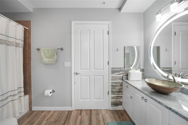 bathroom with hardwood / wood-style flooring, shower / tub combo with curtain, and vanity