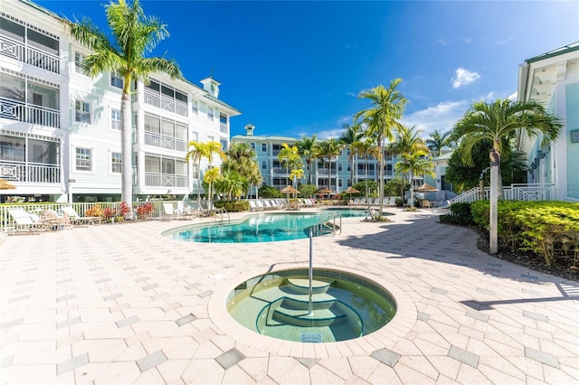 view of swimming pool featuring a patio and a community hot tub