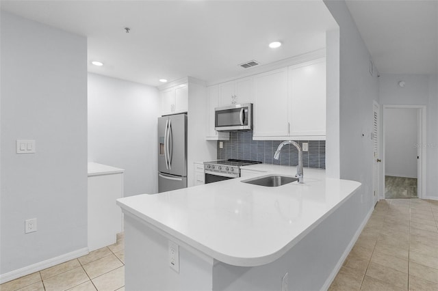 kitchen with white cabinetry, kitchen peninsula, and appliances with stainless steel finishes