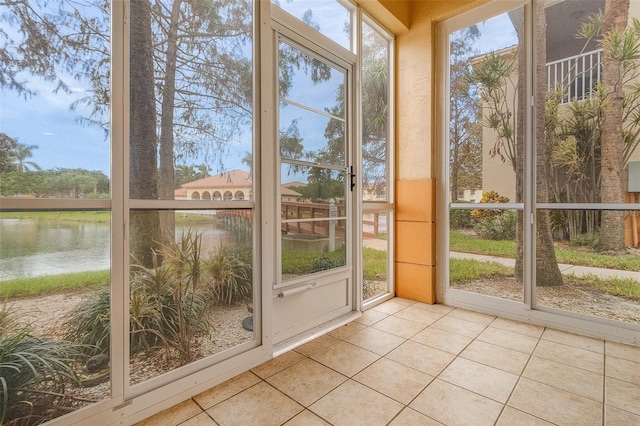 unfurnished sunroom featuring a water view