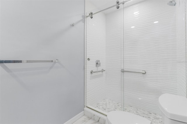 bathroom featuring tiled shower and toilet