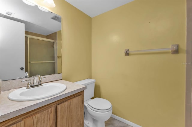 bathroom with toilet, vanity, tile patterned floors, and a shower with door