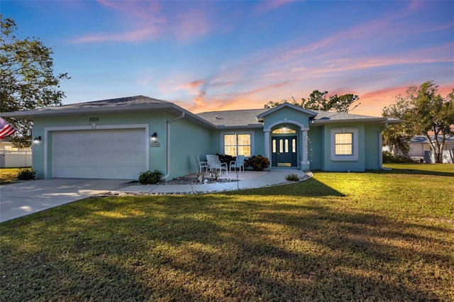 ranch-style house featuring a lawn and a garage