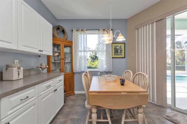 dining space featuring a notable chandelier and dark tile patterned floors