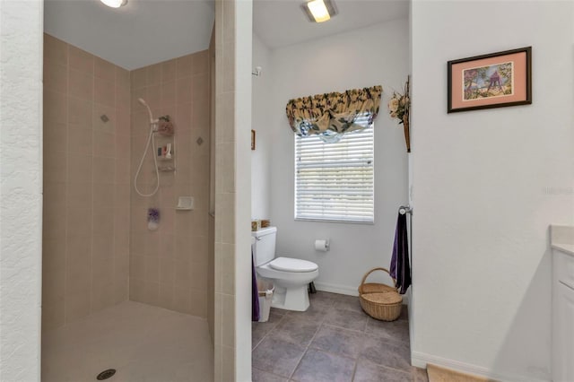 bathroom with a tile shower, vanity, and toilet