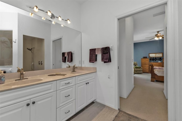 bathroom with ceiling fan, walk in shower, and vanity