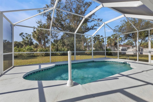 view of pool with a yard, glass enclosure, and a patio area