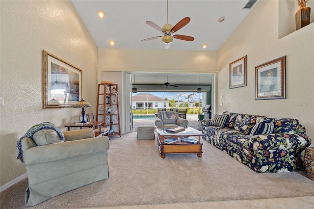 carpeted living room with ceiling fan and high vaulted ceiling