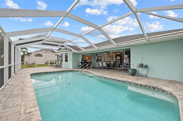 view of swimming pool with a patio, a lanai, and ceiling fan