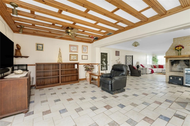 living room with a brick fireplace, ceiling fan, and light tile patterned floors