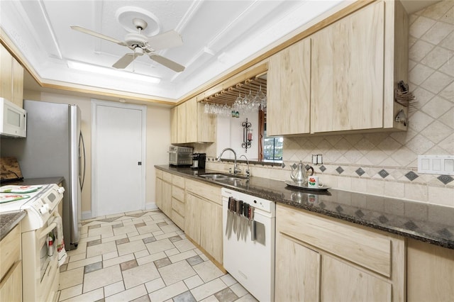 kitchen with sink, light brown cabinetry, ceiling fan, backsplash, and white appliances