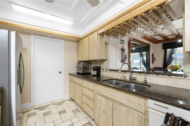 kitchen with light brown cabinets, stainless steel refrigerator with ice dispenser, sink, and white dishwasher