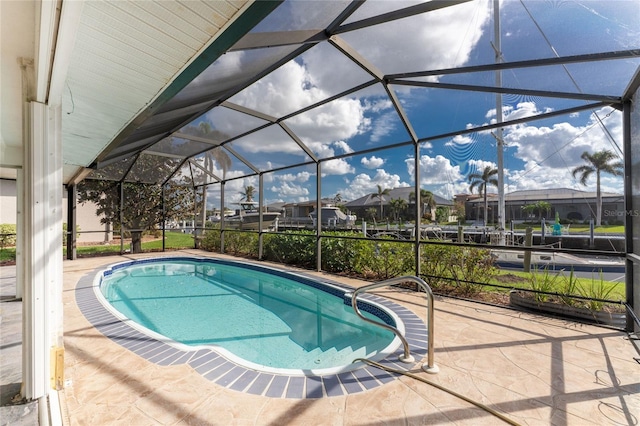 view of swimming pool with glass enclosure and a patio