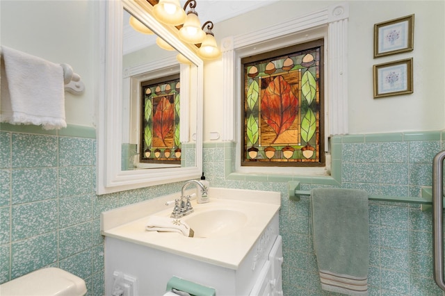 bathroom with tile walls, vanity, ornamental molding, and toilet