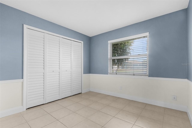 unfurnished bedroom featuring a closet and light tile patterned floors