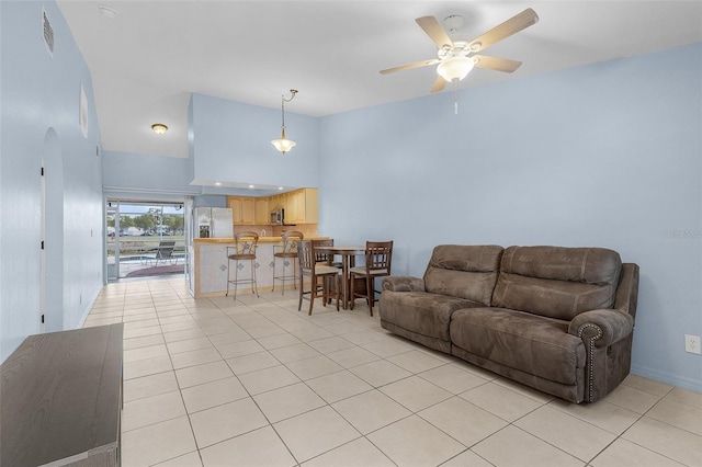 tiled living room with ceiling fan and a towering ceiling