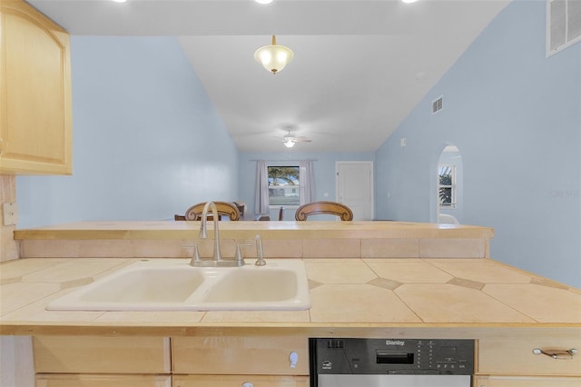 kitchen with light brown cabinets, lofted ceiling, ceiling fan, dishwashing machine, and sink