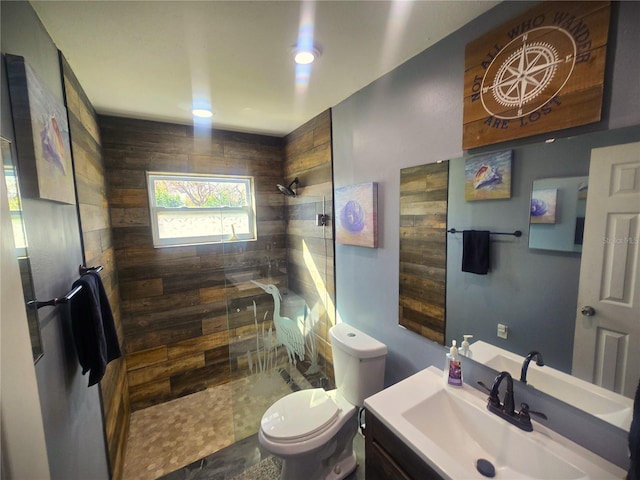 bathroom featuring vanity, toilet, and tiled shower