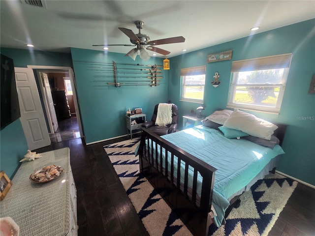 bedroom with dark hardwood / wood-style flooring and ceiling fan