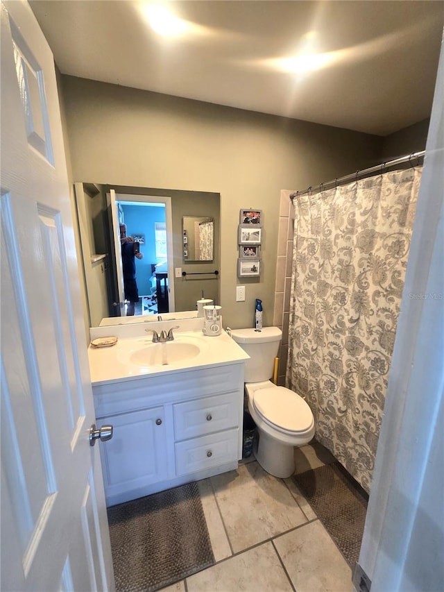 bathroom with vanity, toilet, walk in shower, and tile patterned flooring