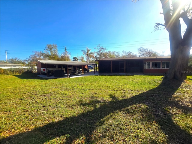 rear view of property with a yard and a carport