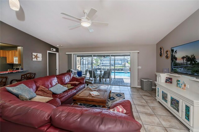 living room featuring lofted ceiling, light tile patterned floors, and ceiling fan