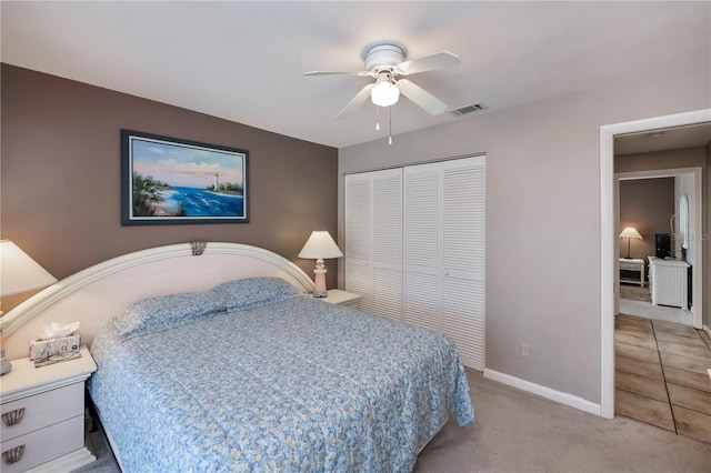 bedroom with light colored carpet, a closet, and ceiling fan