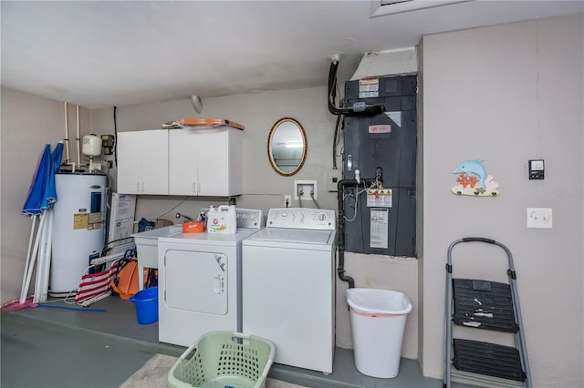 laundry area with electric water heater, sink, heating unit, cabinets, and washer and dryer