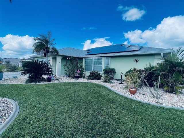 ranch-style home featuring solar panels and a front yard