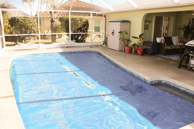 view of pool featuring glass enclosure and a patio