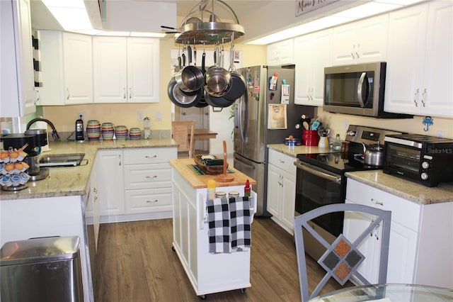 kitchen featuring wood counters, dark hardwood / wood-style flooring, stainless steel appliances, sink, and white cabinets