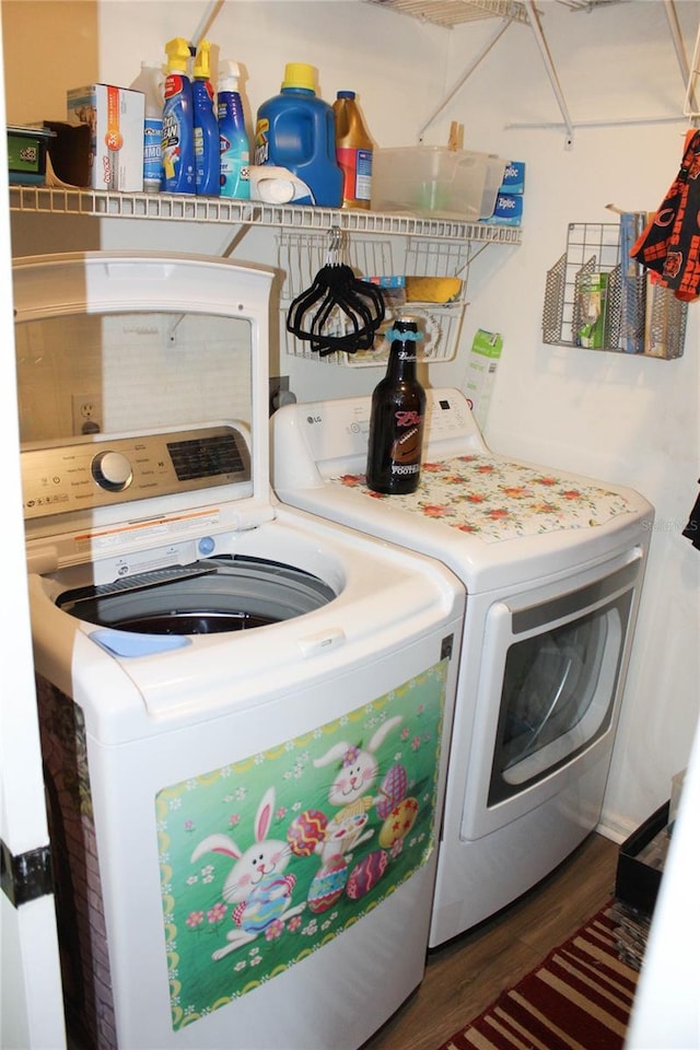 clothes washing area with dark hardwood / wood-style flooring and washing machine and clothes dryer