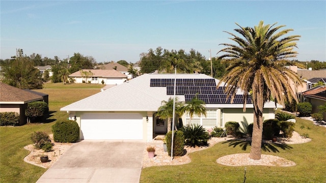 view of front of home with a front yard, solar panels, and a garage