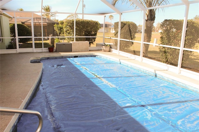 view of swimming pool featuring glass enclosure