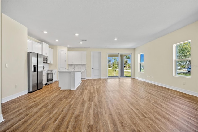 1293 Preston St, Port Charlotte, FL 33952 - unfurnished living room featuring light wood-style flooring and recessed lighting