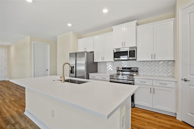 1293 Preston St, Port Charlotte, FL 33952 - kitchen featuring stainless steel appliances, a center island with sink, tasteful backsplash, white cabinetry, and recessed lighting
