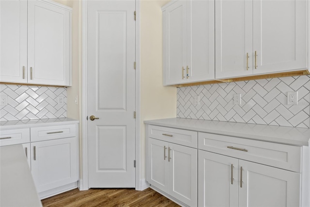 1293 Preston St, Port Charlotte, FL 33952 - kitchen with backsplash, light countertops, white cabinetry, and wood finished floors