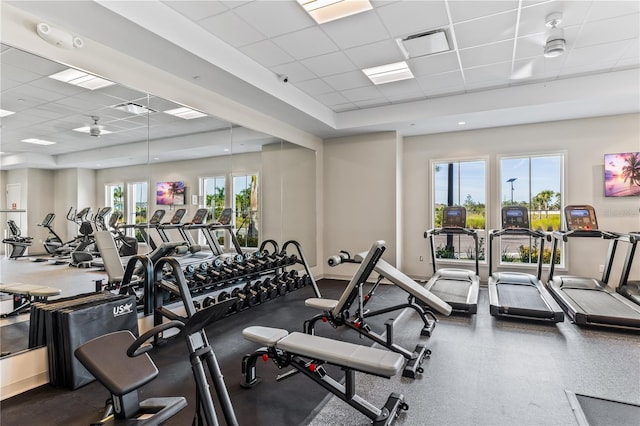 gym with a paneled ceiling and ceiling fan