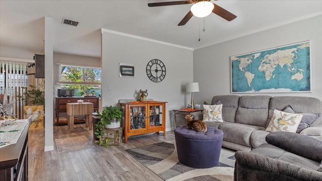 living room with light hardwood / wood-style flooring, ceiling fan, and crown molding