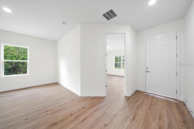 interior space with light wood-style flooring, recessed lighting, visible vents, and baseboards