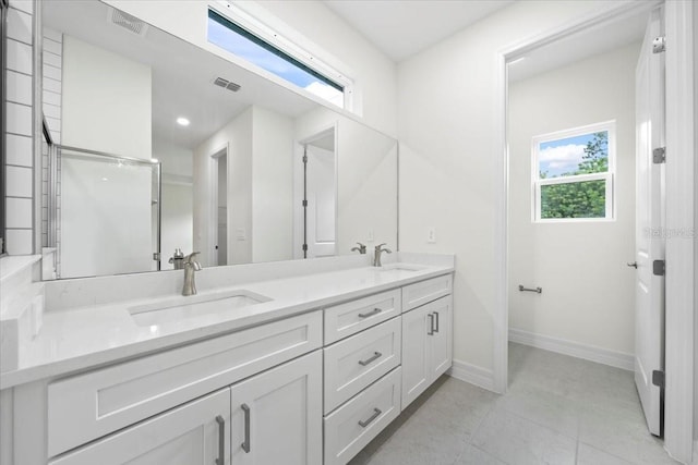 full bath with visible vents, a sink, baseboards, and double vanity