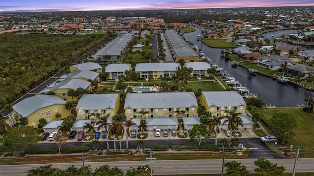 aerial view at dusk featuring a water view