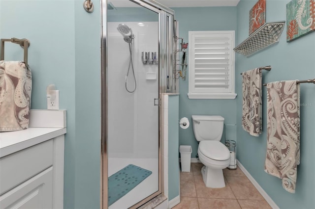 bathroom with tile patterned flooring, vanity, toilet, and a shower with door