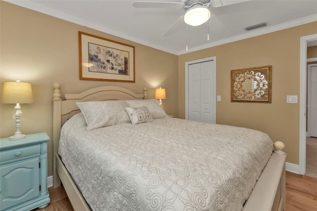 bedroom with ceiling fan, a closet, light wood-type flooring, and ornamental molding