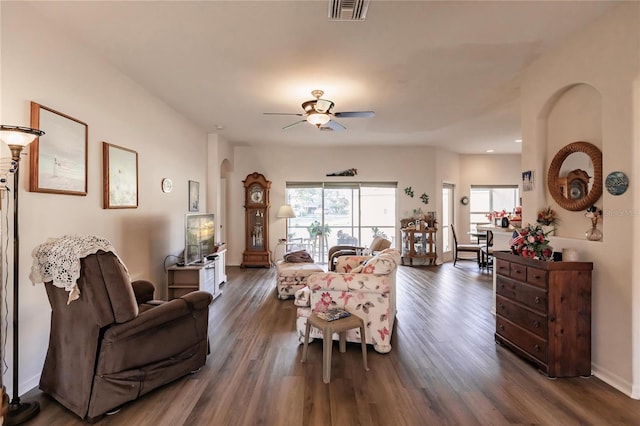 living room with dark wood-type flooring and ceiling fan