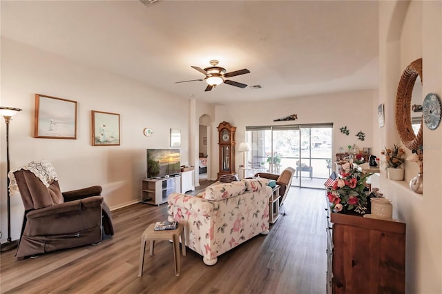 living room with dark wood-type flooring and ceiling fan