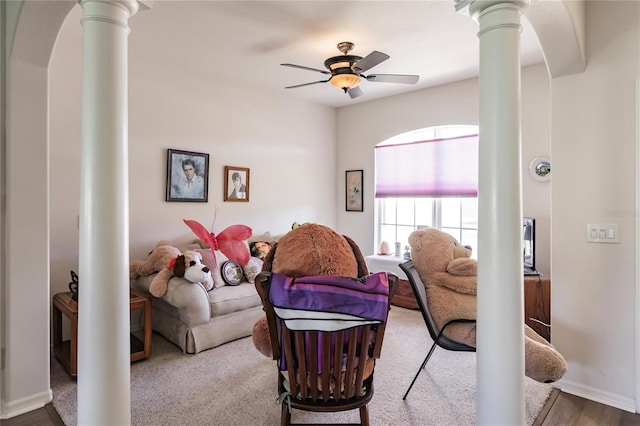 living room featuring hardwood / wood-style flooring, ceiling fan, and decorative columns